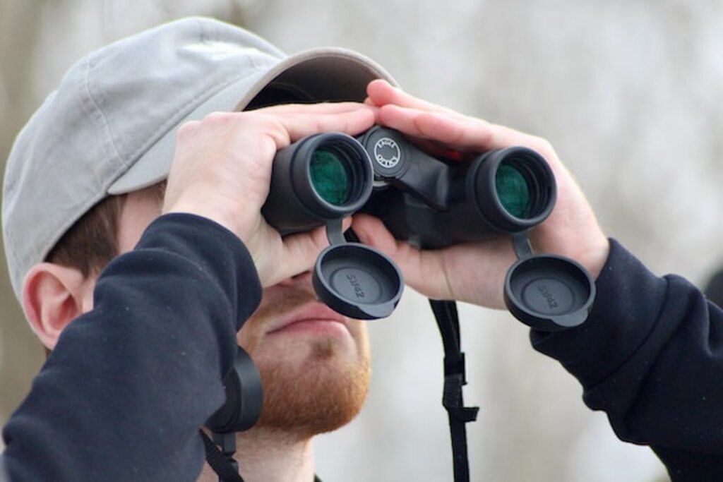 A man birdwatching with his binoculars.