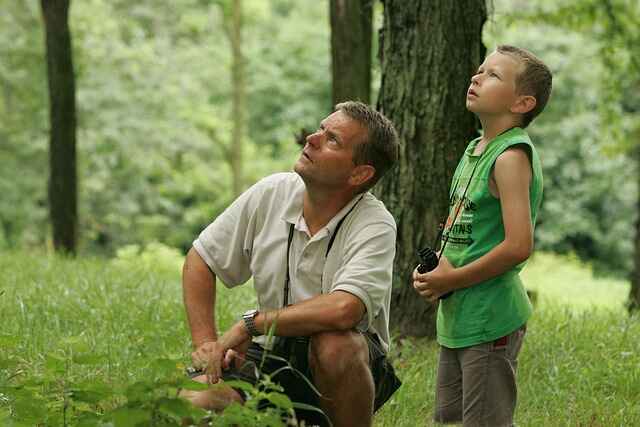 A father and son birdwatching together.