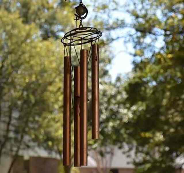 A wind chime hanging in a yard.