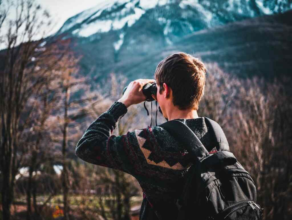 A man with binoculars bird watching.