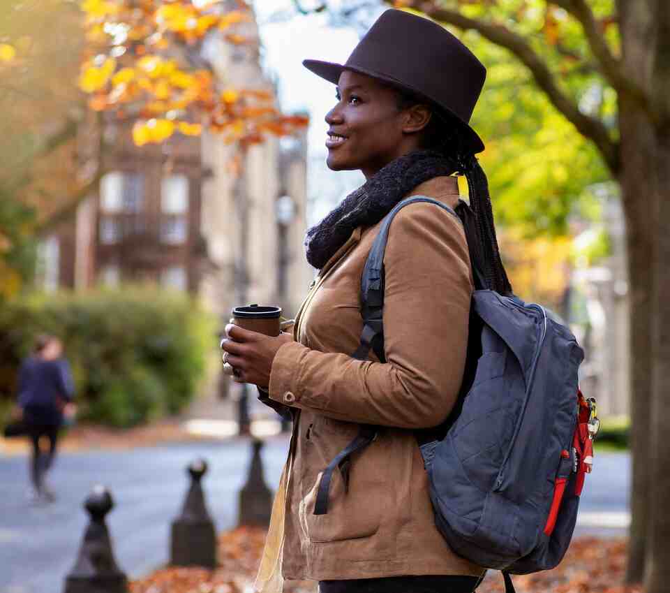 A person birdwatching in the city streets in the fall.